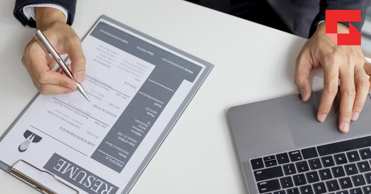 Image of a paper resume next to a laptop