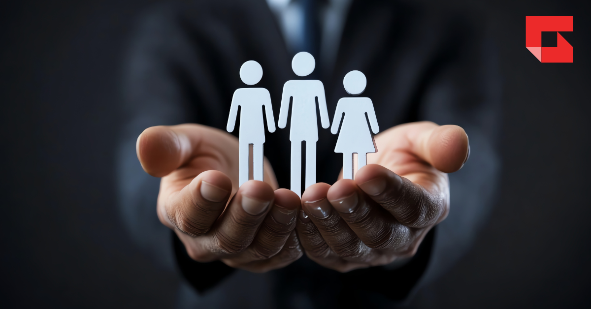 hands holding three paper cutouts of people