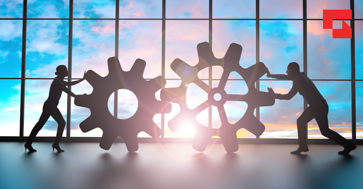 Two people pushing cogs into place