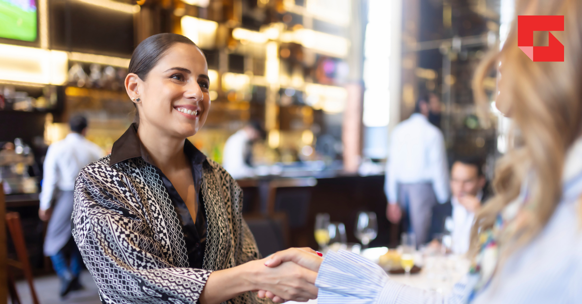 Women shaking hands in a restaurant