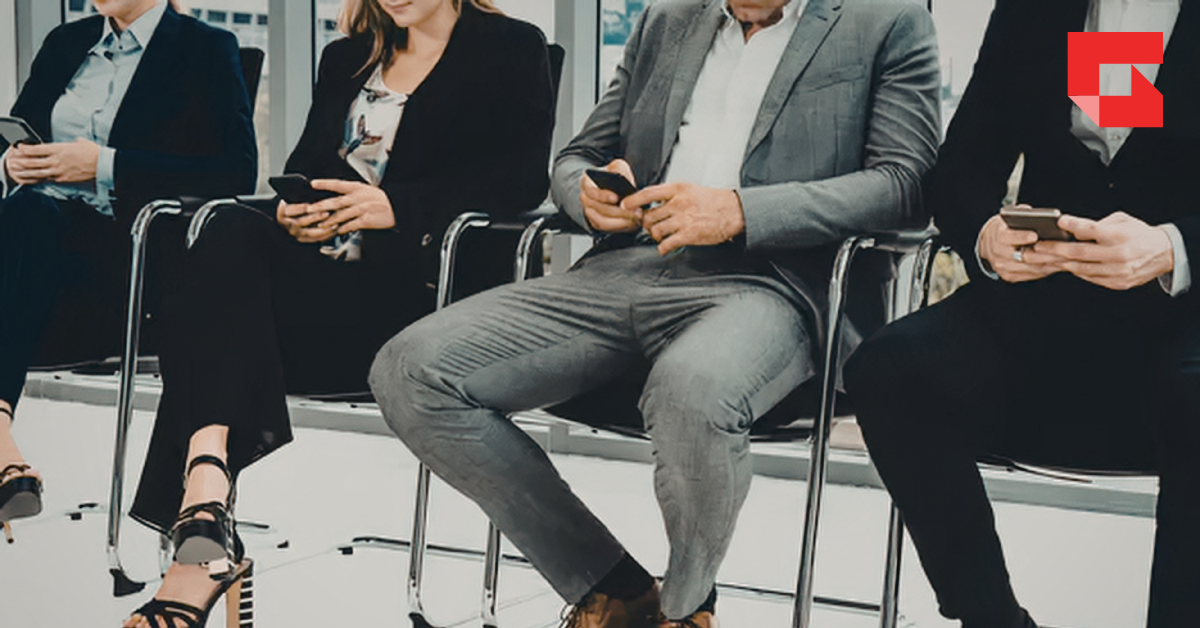 People sitting in a row on their smart phones