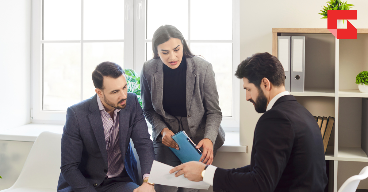 Two men and one woman looking over a document together