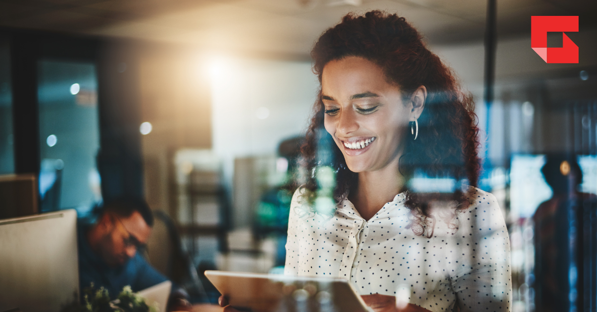 Woman smiling as she works on a tablet