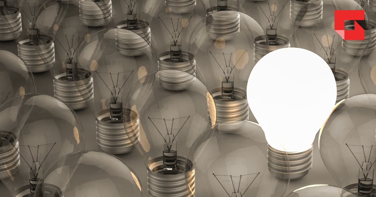 Sea of dark lightbulbs with one lit up