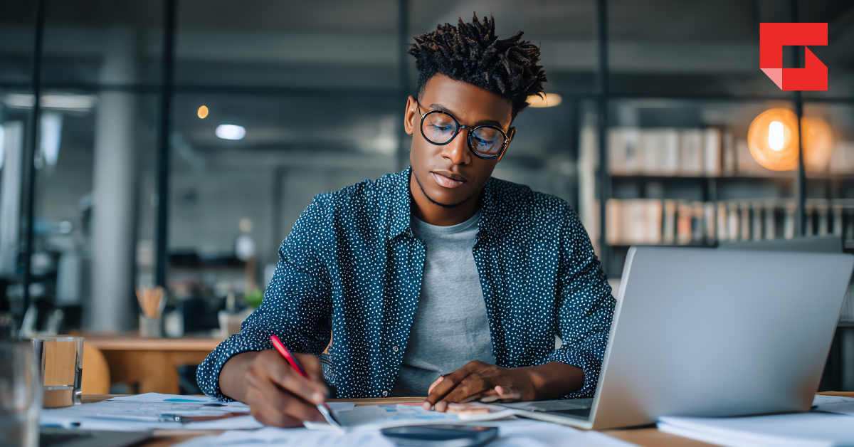 Man doing calculations in front of a computer screen