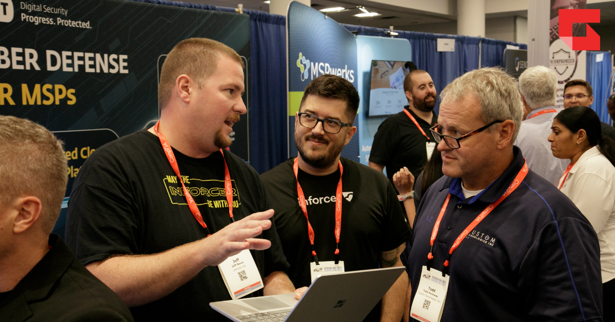 Group of three men talking at an industry event booth
